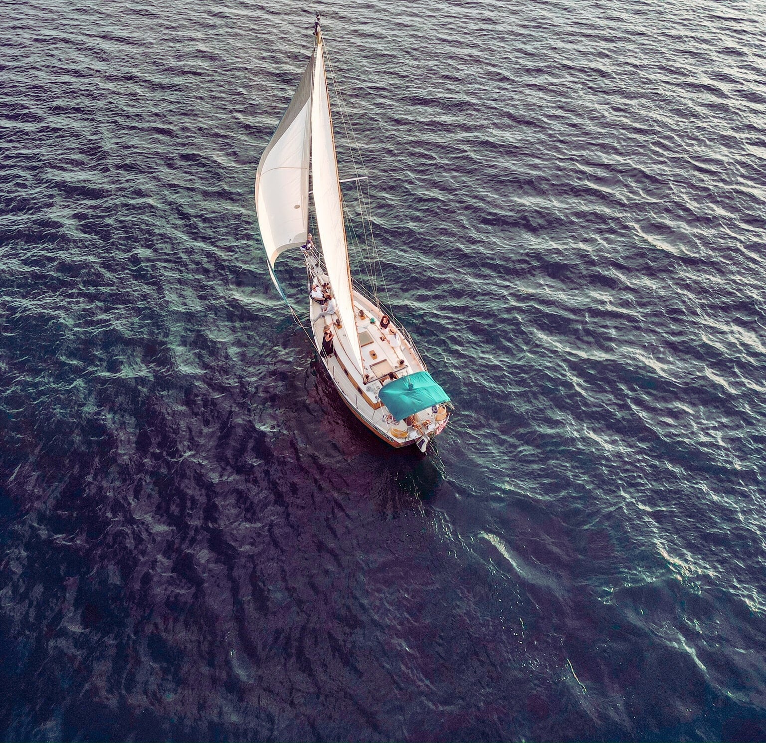 Aerial top-down view of a sailboat on the dark blue waters of Lake Lanier