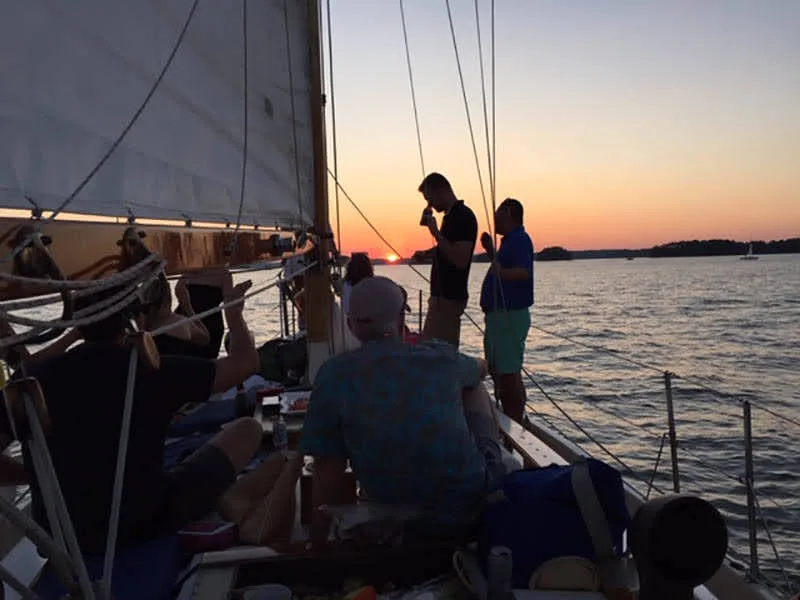 Guests relaxing on deck during a sunset sailing cruise