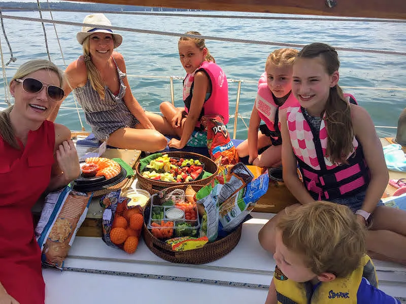 Family with kids enjoying a picnic on the deck of a sailboat on Lake Lanier