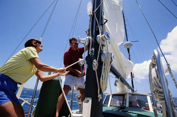 A couple working together to raise the sails during a team building charter on Lake Lanier